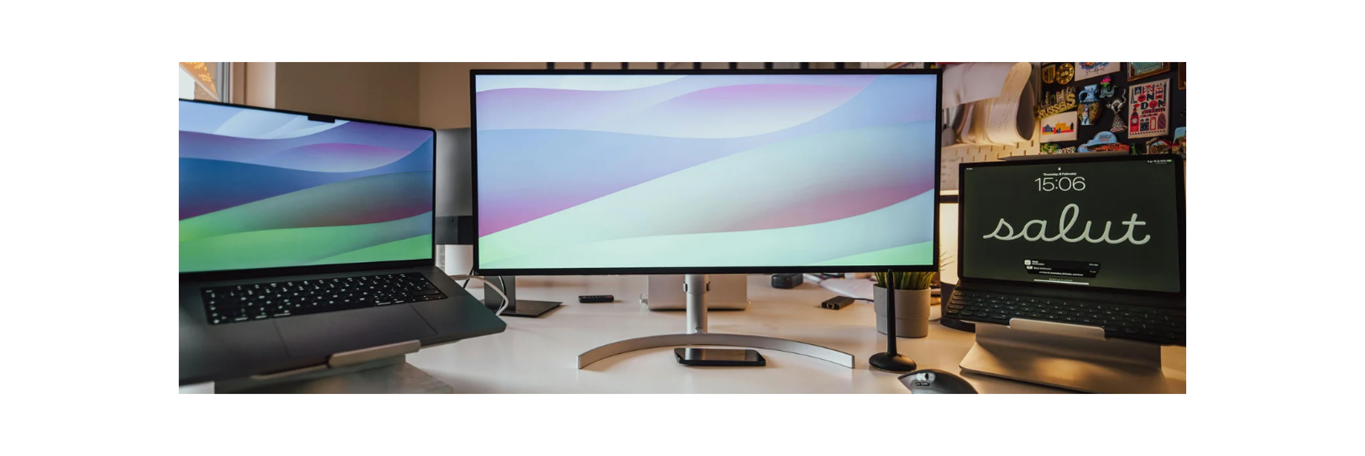 Dva notebooky a jeden monitor na počítačovom stole.