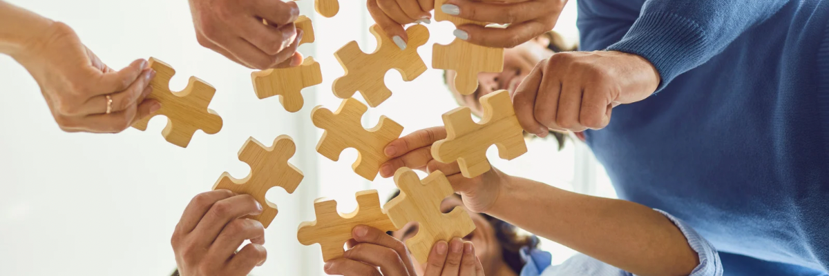 Ľudské ruky skladajú puzzle z dreva